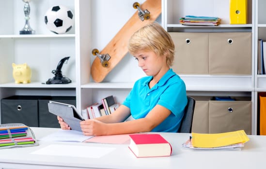 blond boy using tablet computer in his room
