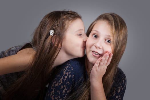 Portrait of8 and 10 year old sisters, studio shot.