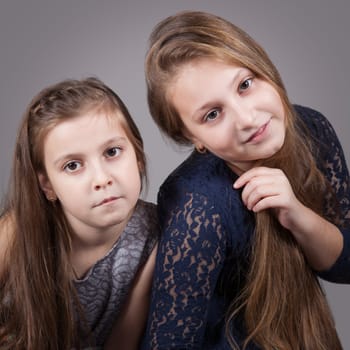 Portrait of8 and 10 year old sisters, studio shot.