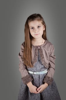 Portrait of a 8 year old girl, nicely dressed, studio shot.