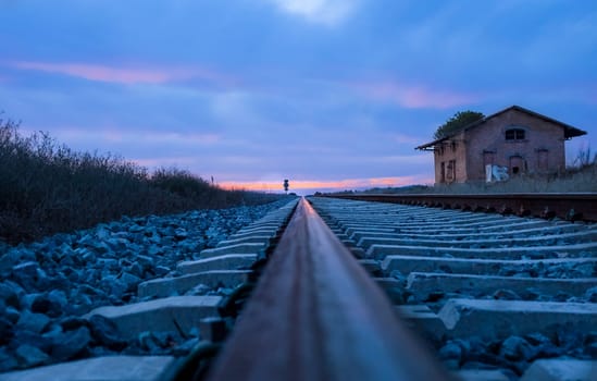 Railway tracks with abandoned rural station at dusk, Badajoz, Spain