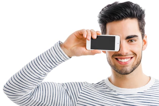 Handsome young man looking and showing something on his phone, isolated on white background