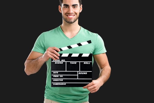 Portrait of handsome young man holding a clapboard, isolated on gray background