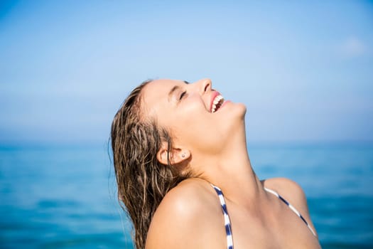 Outdoor portrait of a beautiful young woman with the ocean in the back