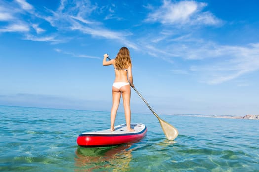A beautiful woman practicing paddle on a beautiful sunny day