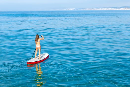 A beautiful woman practicing paddle on a beautiful sunny day