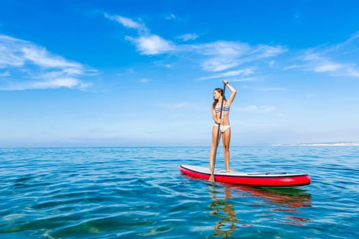A beautiful woman practicing paddle on a beautiful sunny day