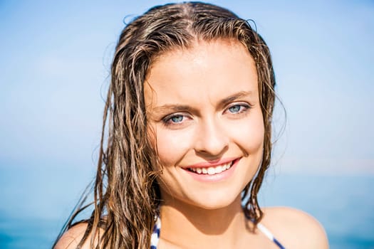Outdoor portrait of a beautiful young woman with the ocean in the back