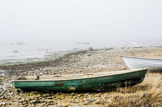 Old fishing boat at coast foggy in the morning