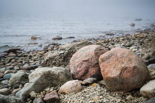 Stony coast of Baltic sea foggy in the morning