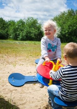 Boy and girl swinging on a swing