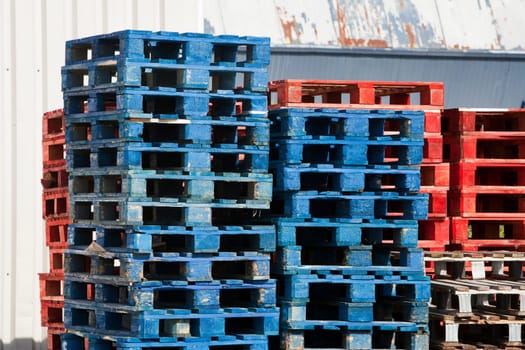 A stack of blue and red wooden pallets