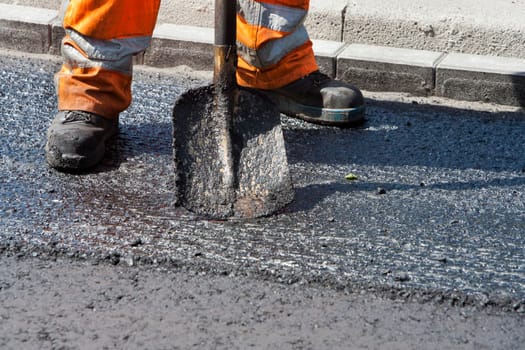 Manual asphalt worker with his shovel