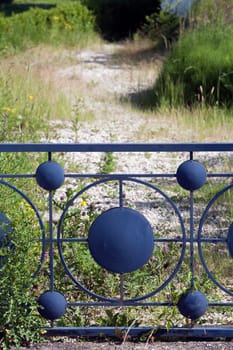 Footpath behind a beautiful blue retro metal fence