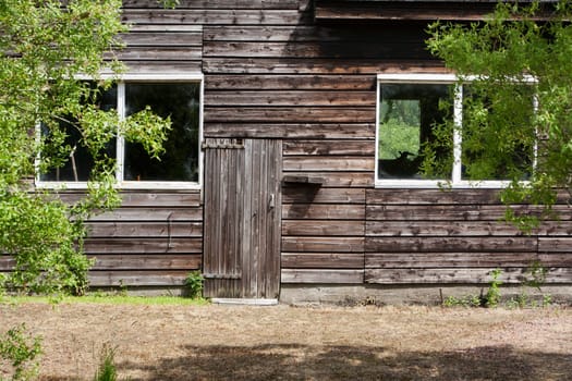 Old wooden barn with big windows and a very small door