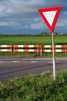 Dangerous T intersection with a road sign for give way priority yield road