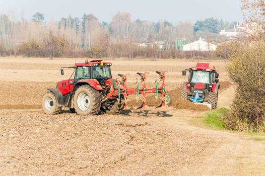 Agricultural labor, Red Tractor plowing a field