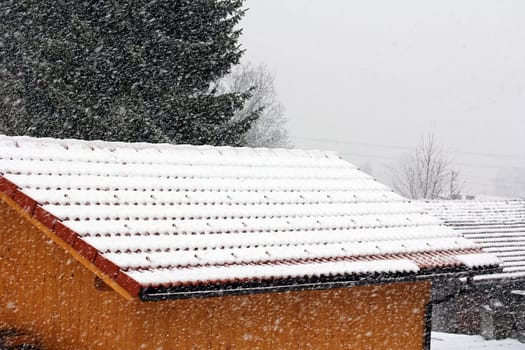 Snow catch hooks on a house roof protect against roof avalanches in heavy snowfall