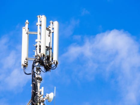 Repeater for mobile phones on top of a building with blue sky and clouds backgrond