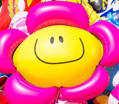The sun in the face. Image of a flower smiley baloon that look and follow the sun