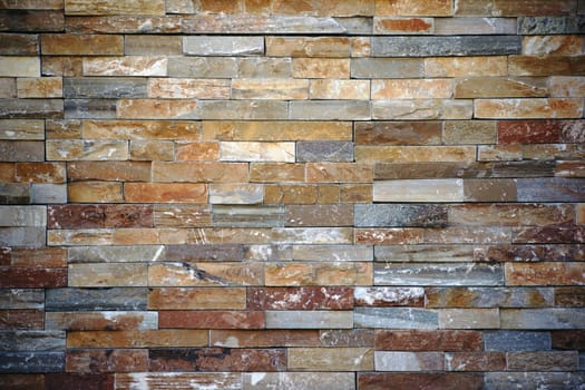 A striking wall with differently coloured and patterned bricks.
