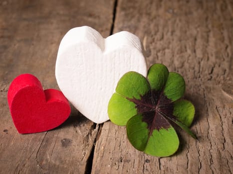 Two heart shapes with a clover on an old wooden table