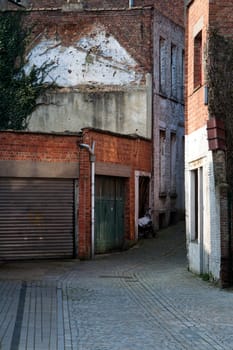 Garage doors and a small dark alley in a residential district of Mechelen in Belgium. It's an old but clean neighborhood.