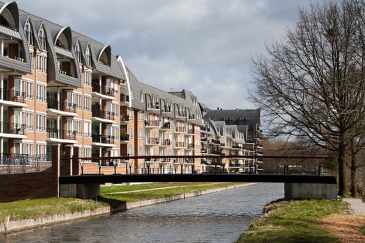 Nice Apartments in an apartment block with water view. There's a woodchips footpath along the water to a bridge. This residential district is located in Voorschoten in the Netherlands.