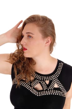 A closeup image of a blond woman in a black dress with silver trimmings.holding one hand behind her head, isolated for white background..