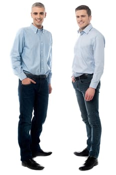 Happy young friends posing with hands in pockets