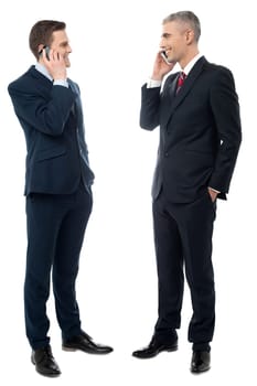 Happy corporate executives discussing via cell phone