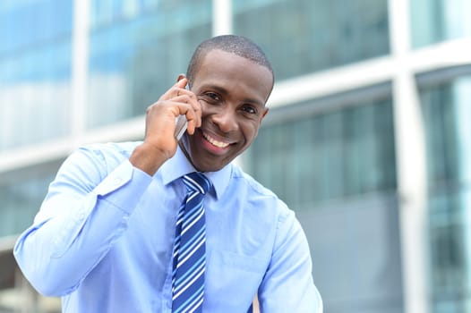 Happy male executive speaking using cell phone
