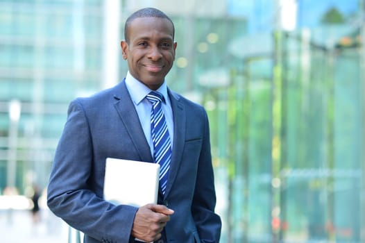 Handsome business man posing with tablet PC