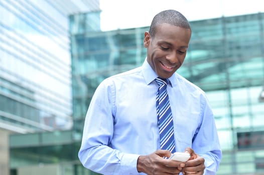 Businessman using mobile phone outside the office