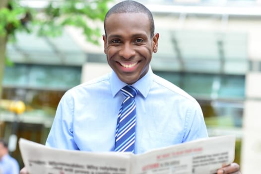 Middle aged business man smiling with magazine