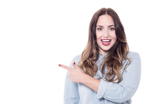 Happy woman pointing at copy space over white
