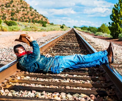 famous cow-boy boots and feets across train tracks