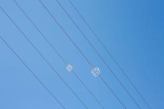 Power line wires over blue sky. Closeup