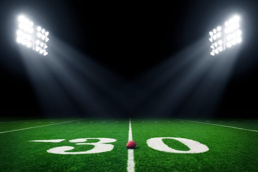 Football field illuminated by stadium lights
