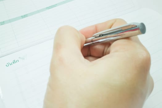 Hand on metallic pen write on the paper, stock photo