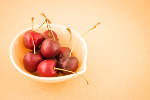 Bowl of cherries on warm vintage background, stock photo