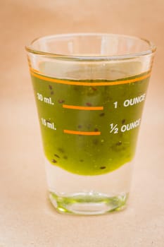 Glass shot of kiwi syrup, stock photo