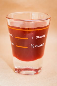 Glass shot of strawberry syrup, stock photo