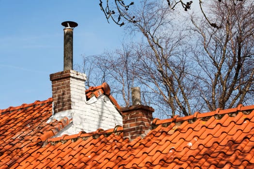 Chimneys on a roof with red roof tiles