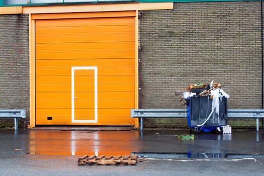 Wheeled garbage container and an orange door