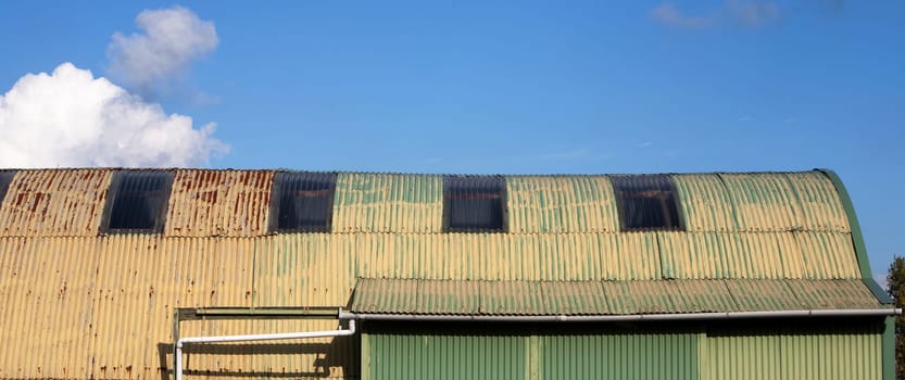 Old yellow green shed made from corrugated iron sheets