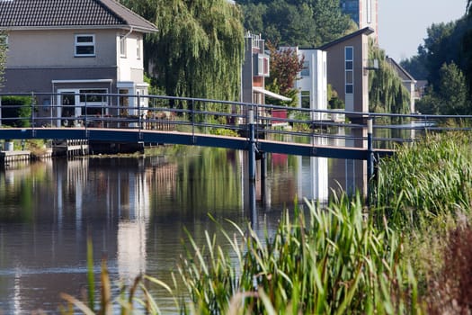 Waterfront houses and a small blue bridge in front