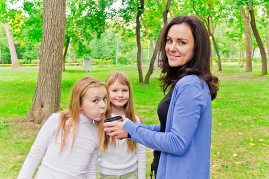 Photo of woman with two girls drinking tea
