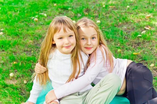 Photo of two girls sitting on grass in summer
