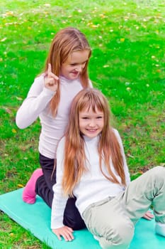Photo of two girls sitting on grass in summer